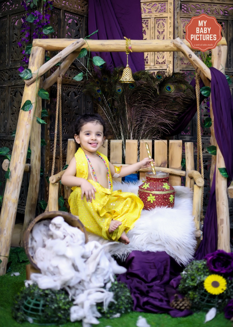 Happy baby girl on a swing (jhula) for a Janmashtami photoshoot