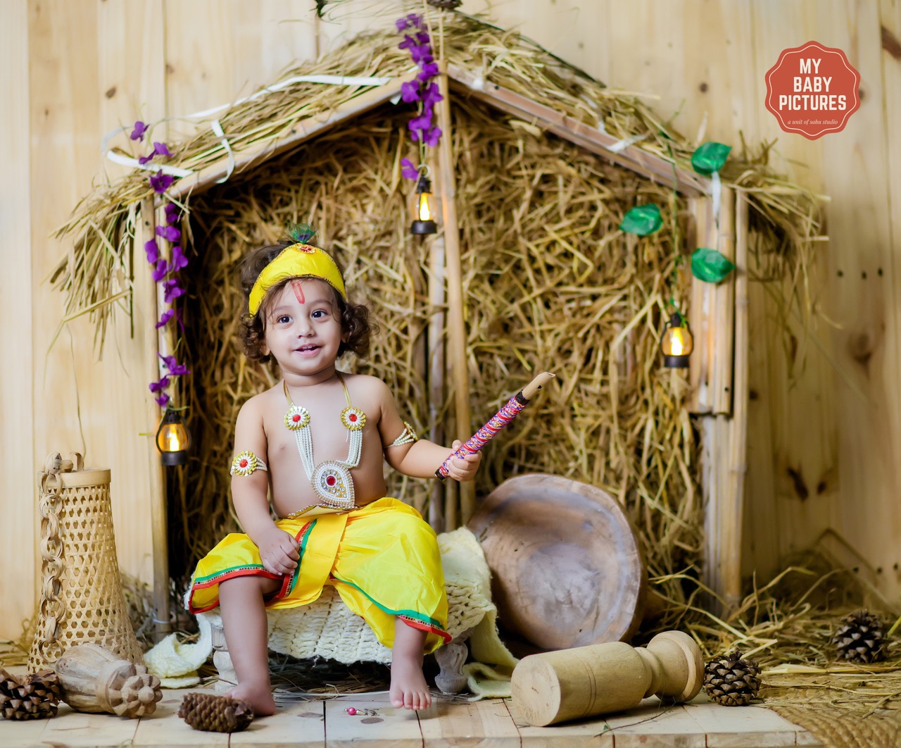 Baby boy in Krishna costume in a rustic hut (kutiya) theme photoshoot
