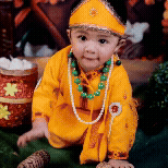 Animated GIF of a cute baby dressed in a yellow Krishna costume